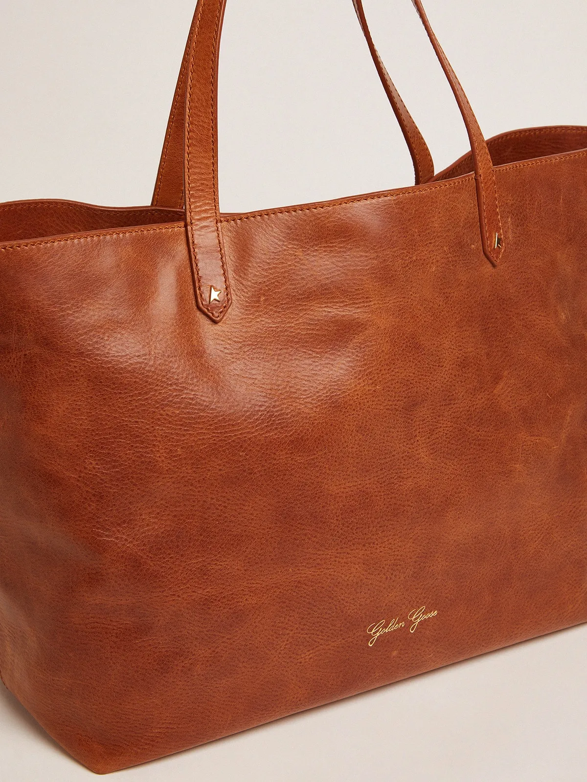 Pasadena Bag in tan-colored glossy hammered leather with gold logo on the front