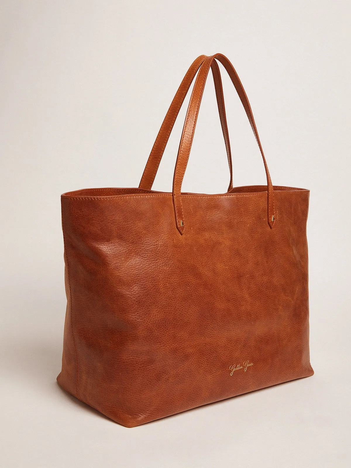 Pasadena Bag in tan-colored glossy hammered leather with gold logo on the front